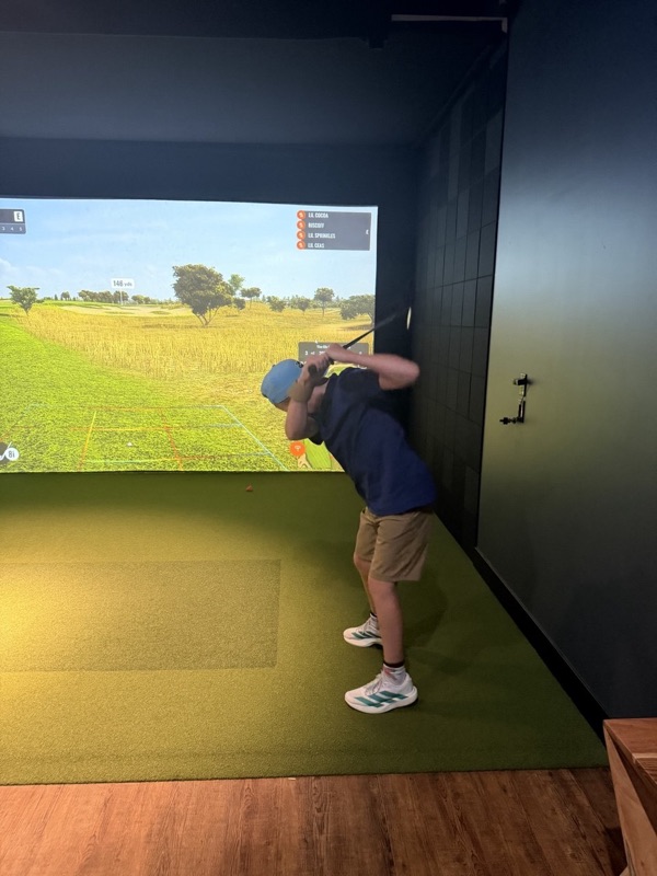 A junior golfer holding a full finish after an iron shot