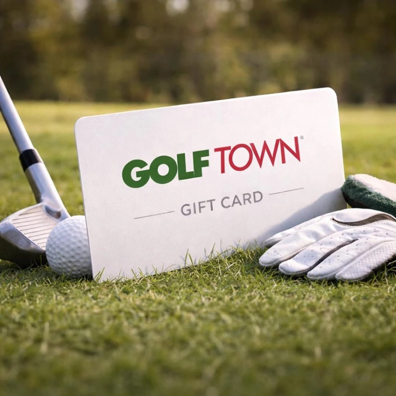 A Golf Town gift card on the grass beside a ball and glove